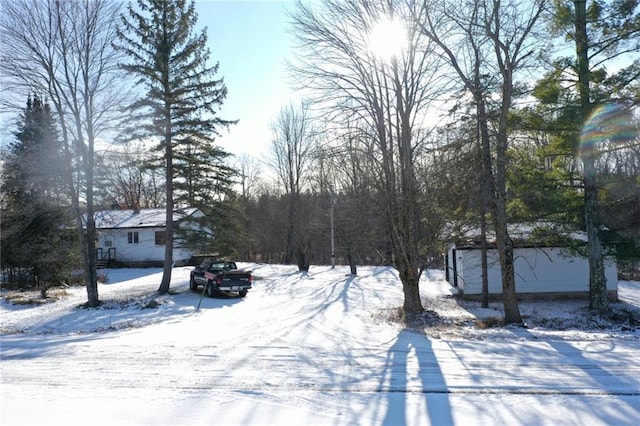 yard covered in snow with an outdoor structure and a garage