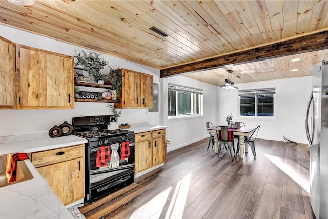 kitchen featuring black gas range, stainless steel fridge, decorative light fixtures, beam ceiling, and dark hardwood / wood-style flooring