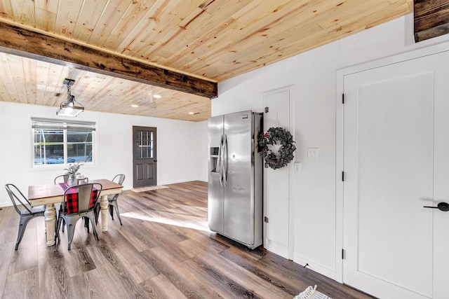 dining space with hardwood / wood-style floors, beamed ceiling, and wood ceiling