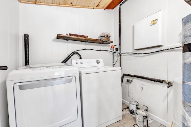 clothes washing area with wooden walls, wooden ceiling, and independent washer and dryer