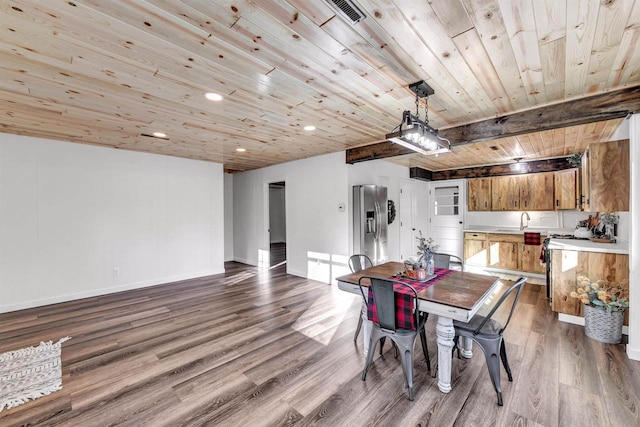 dining area with sink, beamed ceiling, wood ceiling, and hardwood / wood-style flooring