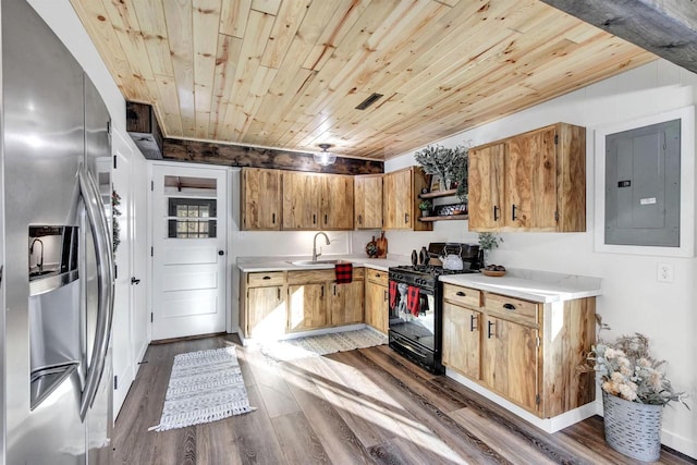 kitchen with gas stove, sink, dark wood-type flooring, stainless steel refrigerator with ice dispenser, and electric panel