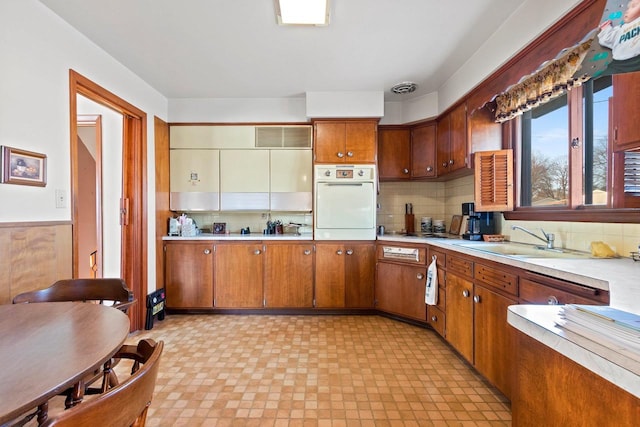 kitchen featuring backsplash, sink, and oven