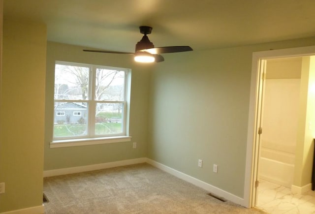 spare room featuring ceiling fan and light carpet