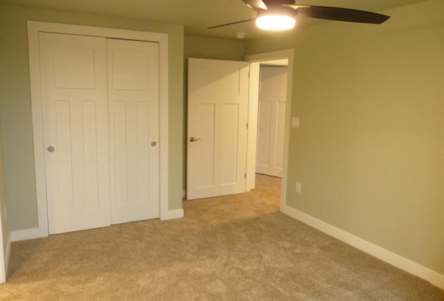 unfurnished bedroom with ceiling fan, a closet, and light colored carpet