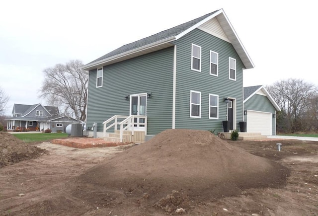 view of home's exterior with cooling unit and a garage