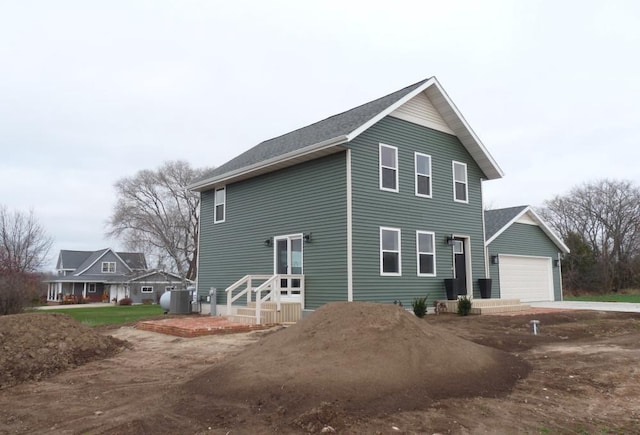 view of side of home with central AC unit and a garage