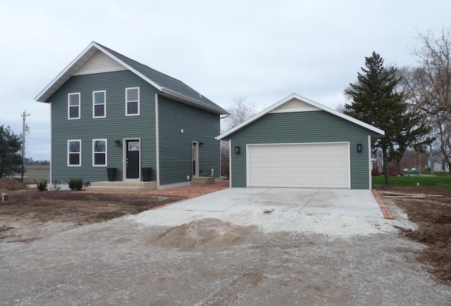 view of front of home with a garage and an outbuilding