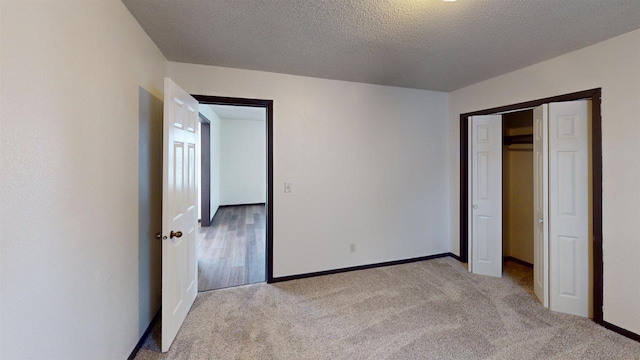 unfurnished bedroom with a closet, light colored carpet, and a textured ceiling