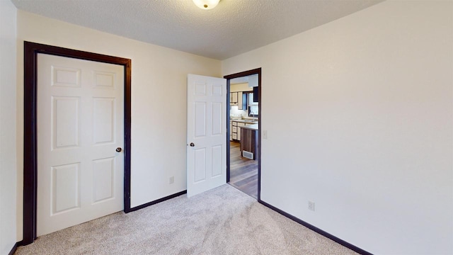 unfurnished bedroom featuring light colored carpet and a textured ceiling