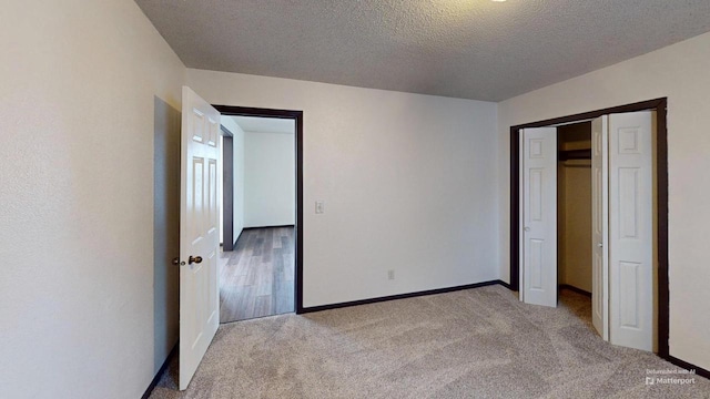 unfurnished bedroom featuring carpet, a textured ceiling, and a closet