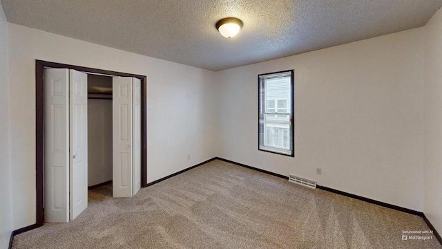 unfurnished bedroom featuring a closet, carpet floors, and a textured ceiling