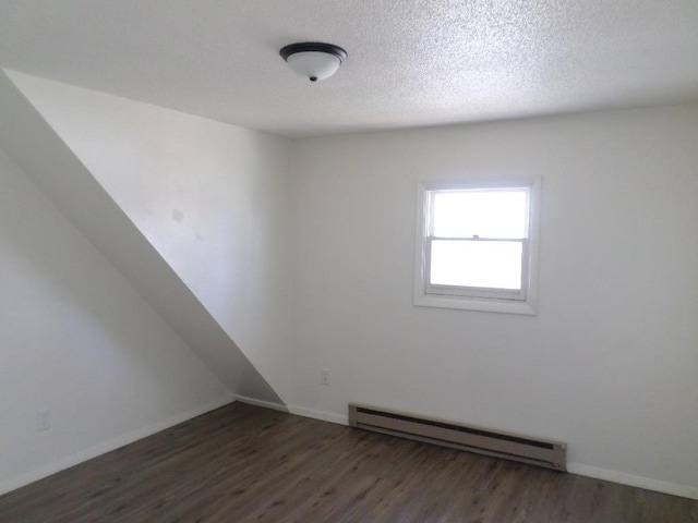 spare room with a textured ceiling, dark hardwood / wood-style floors, and baseboard heating