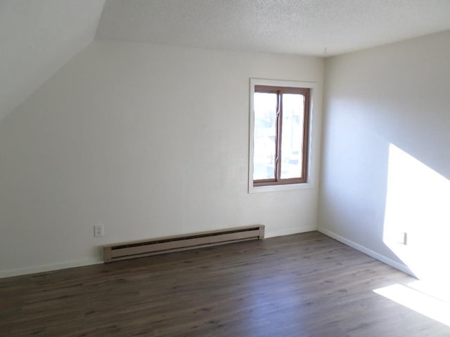 interior space with baseboard heating, vaulted ceiling, dark wood-type flooring, and a textured ceiling