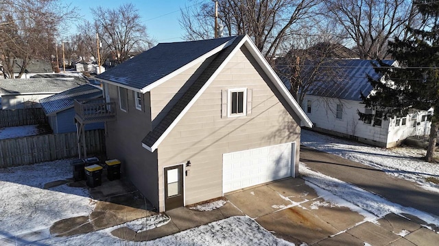 view of snow covered exterior with a garage