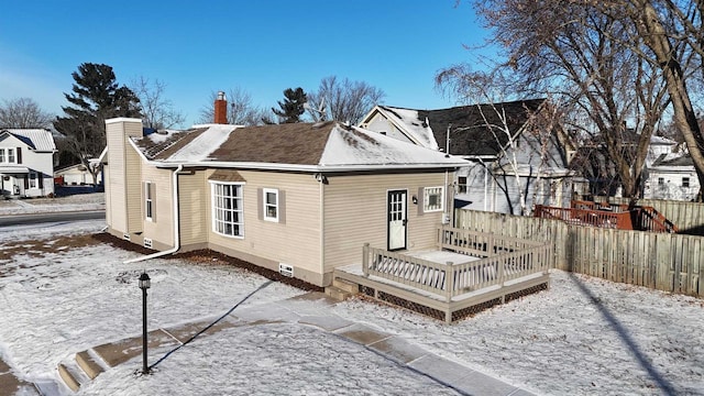 snow covered house with a deck