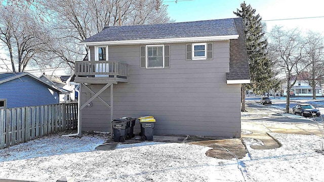 snow covered house featuring a balcony