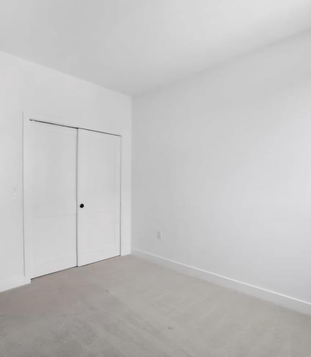 unfurnished bedroom featuring carpet floors and a closet