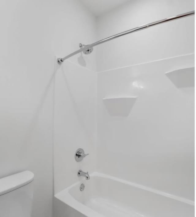 bathroom featuring bathing tub / shower combination and toilet