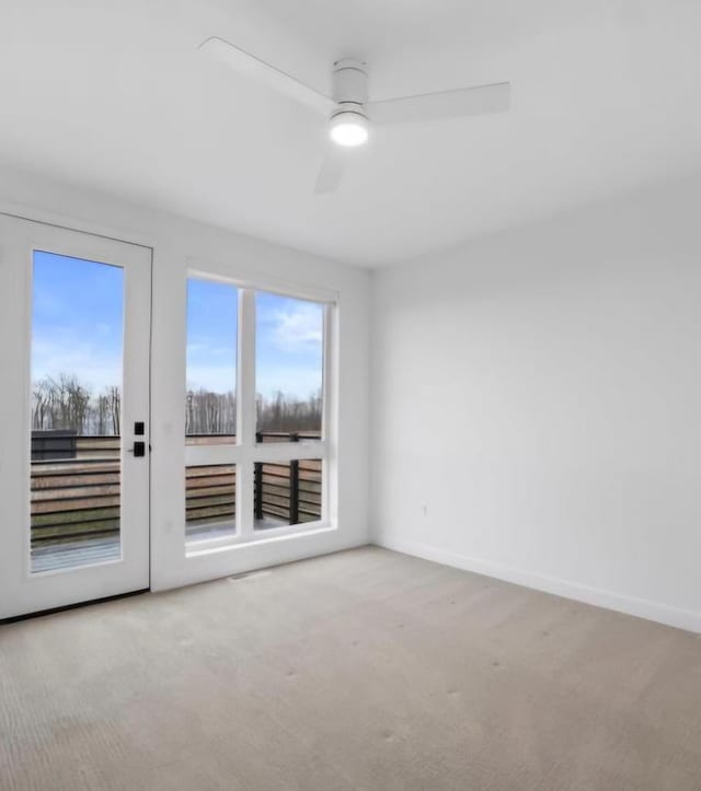 carpeted spare room with ceiling fan