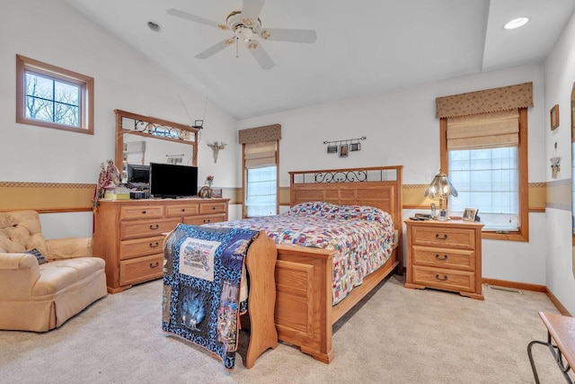 carpeted bedroom with ceiling fan, vaulted ceiling, and multiple windows