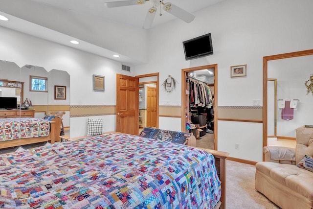 bedroom featuring light carpet, ceiling fan, a spacious closet, a towering ceiling, and a closet