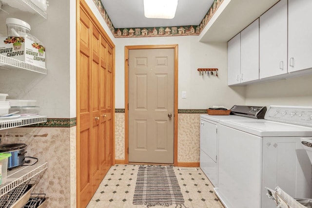 clothes washing area with washer and clothes dryer and cabinets