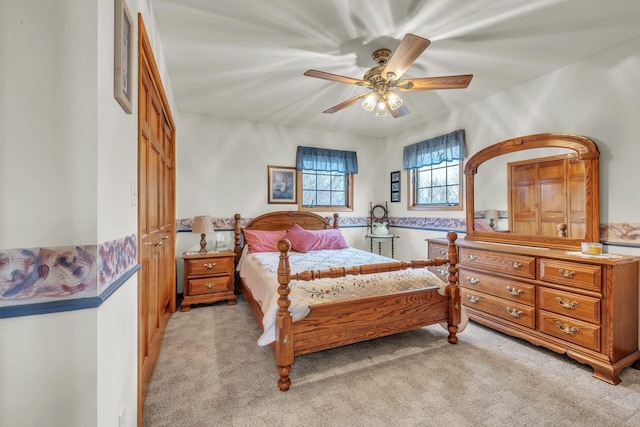 carpeted bedroom featuring a closet and ceiling fan