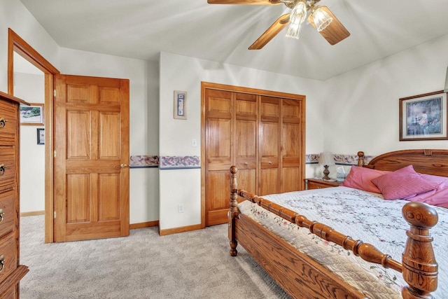 bedroom with ceiling fan, light carpet, and a closet