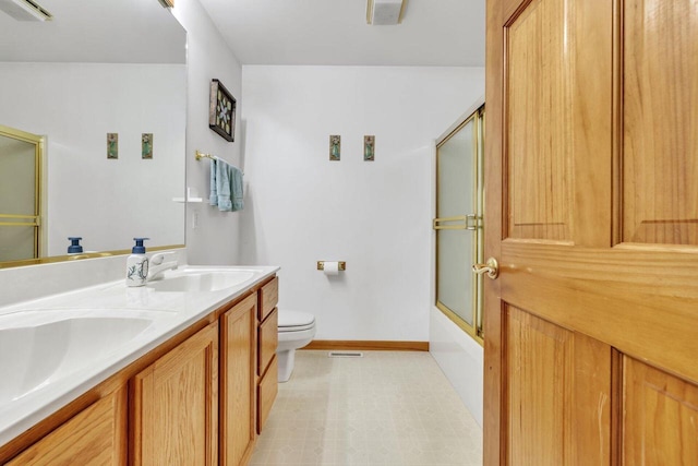 full bathroom featuring vanity, toilet, and shower / bath combination with glass door