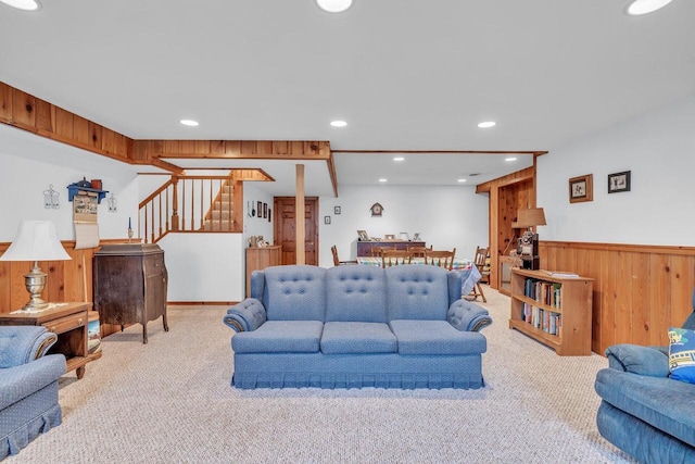 carpeted living room featuring wooden walls