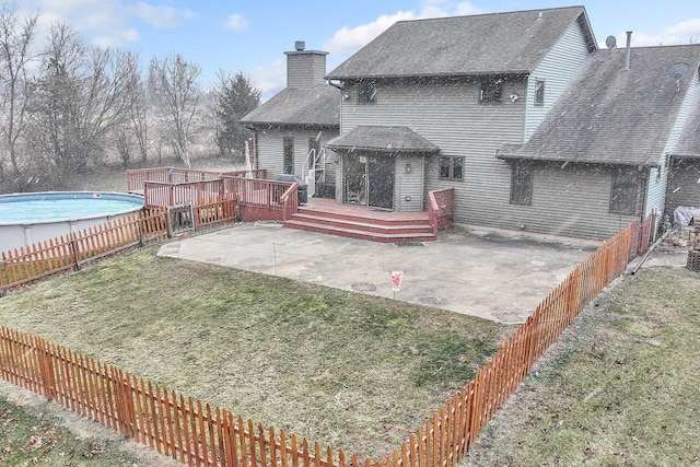 back of property with a lawn, a pool side deck, and a patio