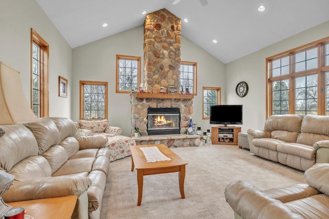 carpeted living room featuring a stone fireplace, ceiling fan, and high vaulted ceiling