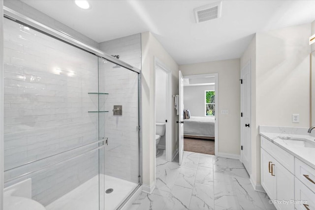 bathroom with vanity, toilet, and a shower with shower door