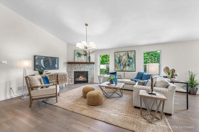 living room featuring a chandelier, a fireplace, a healthy amount of sunlight, and hardwood / wood-style flooring