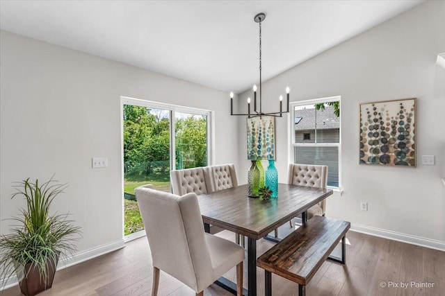 dining area featuring a notable chandelier, dark hardwood / wood-style floors, and vaulted ceiling