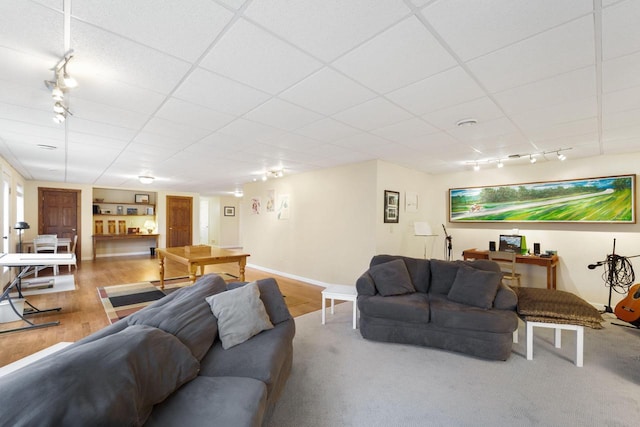 living room with a paneled ceiling, rail lighting, and hardwood / wood-style flooring