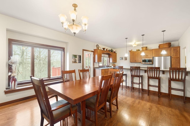 dining area featuring hardwood / wood-style floors and an inviting chandelier