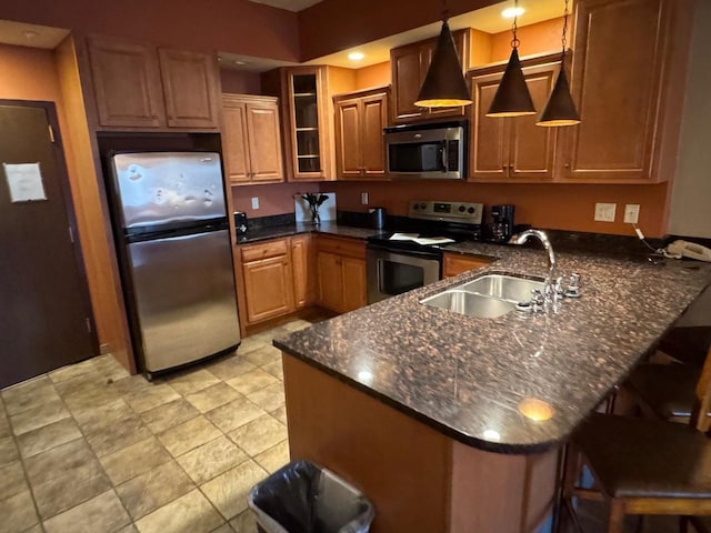 kitchen featuring kitchen peninsula, pendant lighting, sink, and stainless steel appliances