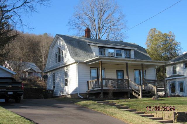 bungalow-style house featuring covered porch and a front lawn