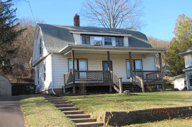 bungalow-style house with a porch and a front lawn