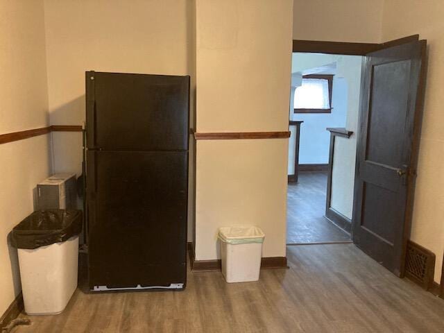 kitchen featuring hardwood / wood-style flooring and black refrigerator