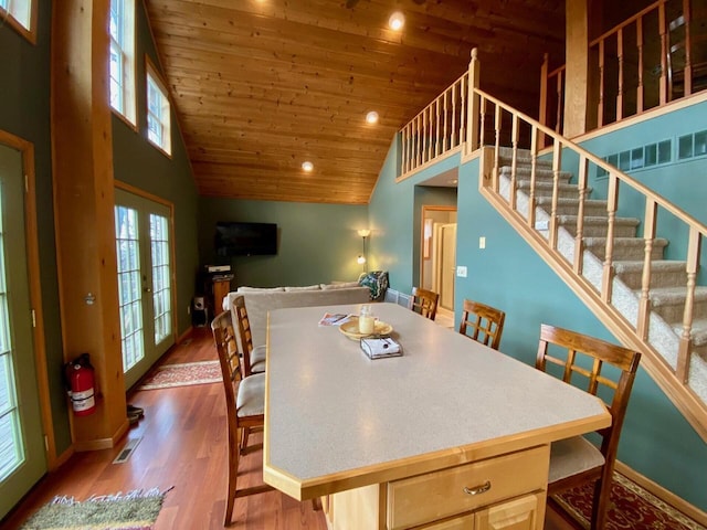 dining room featuring french doors, high vaulted ceiling, wood ceiling, and hardwood / wood-style floors