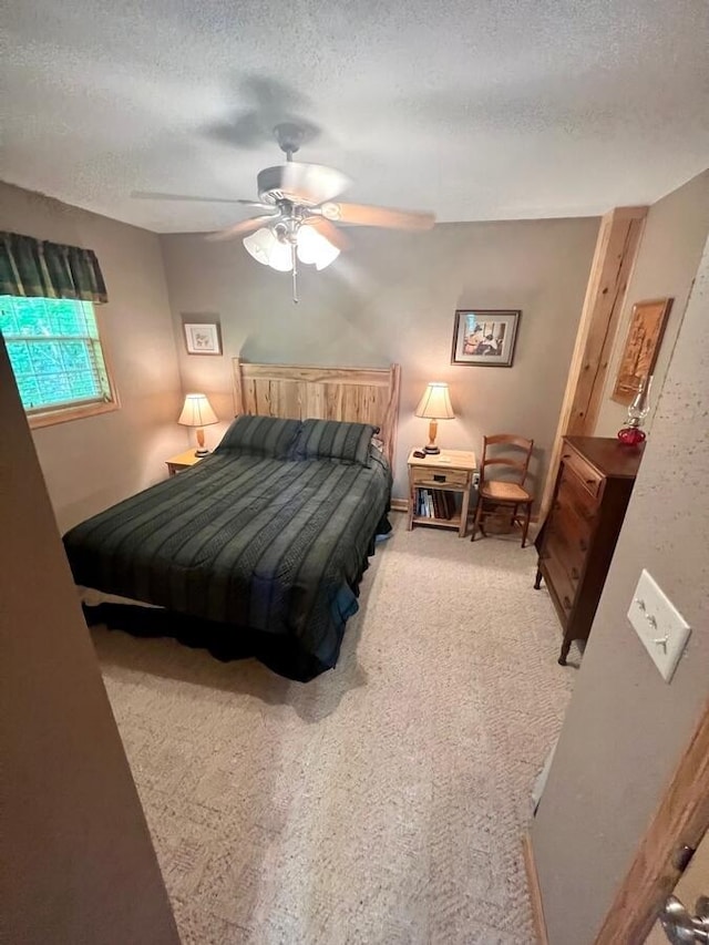 bedroom featuring carpet flooring, a textured ceiling, and ceiling fan