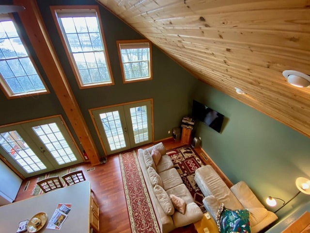 unfurnished living room with wood-type flooring, high vaulted ceiling, and french doors