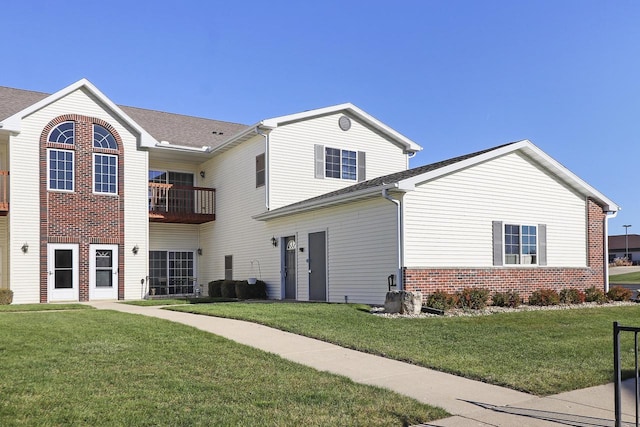 view of front of property featuring a balcony and a front yard