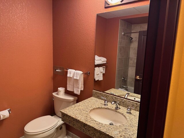 full bathroom with sink, tiled shower / bath, and toilet