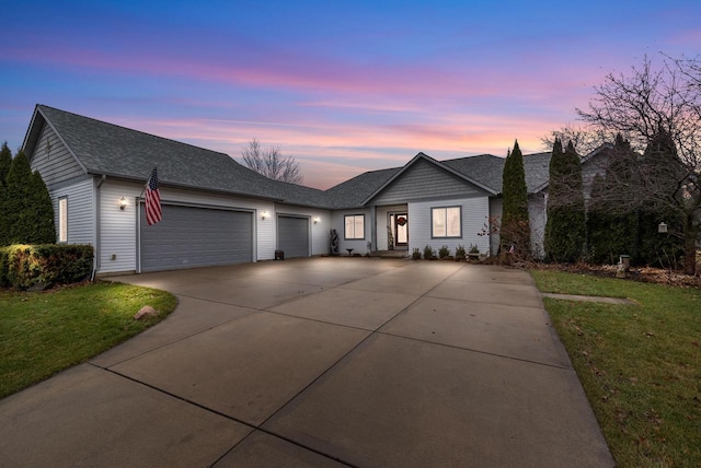 ranch-style home featuring a yard and a garage