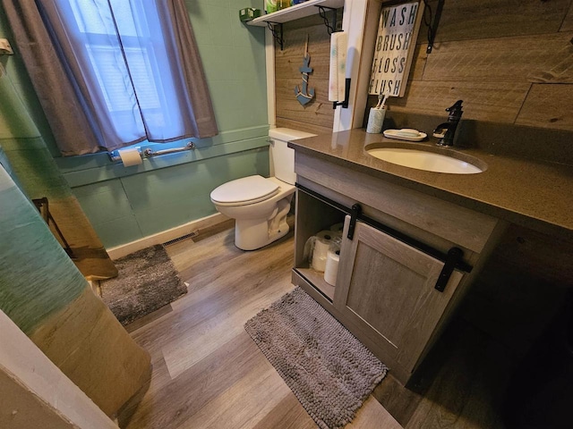 bathroom with hardwood / wood-style floors, vanity, and toilet