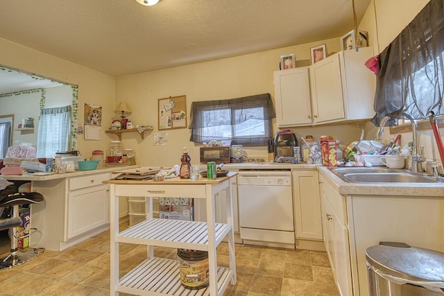 kitchen featuring a textured ceiling, white dishwasher, white cabinetry, and sink